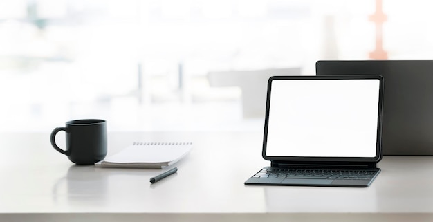 Workspace mockup open blank screen digital tablet with magic keyboard on wooden desk in office room banner