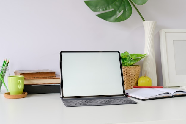 Workspace mockup tablet and office supplies on office desk.