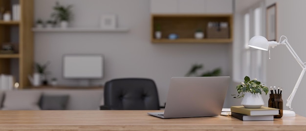 Workspace with laptop and copy space on wood tabletop over blurred modern home office