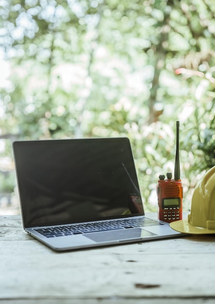 workspace with laptop a hard hat on a wooden surface likely belonging to a professional