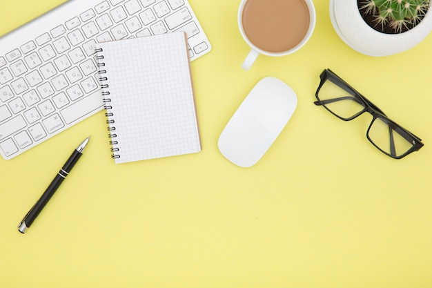 Workspace with tablet, keyboard, coffee cup and eyeglasses