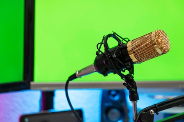 Workstation with microphone and monitors with green screen for montage