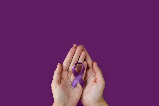 World Alzheimer's day September 21 International Epilepsy Day Adult hands holding purple ribbon