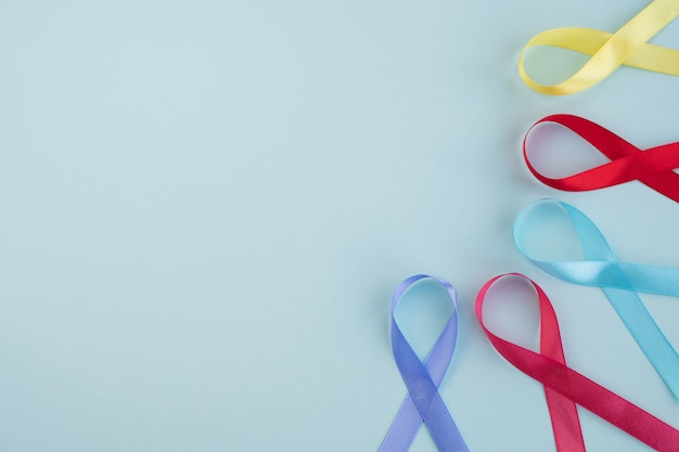 Photo world cancer day. colorful ribbons cancer awareness on light blue background