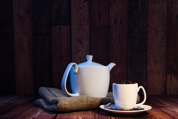 World coffee day concept white porcelain cup and teapot with coffee beans