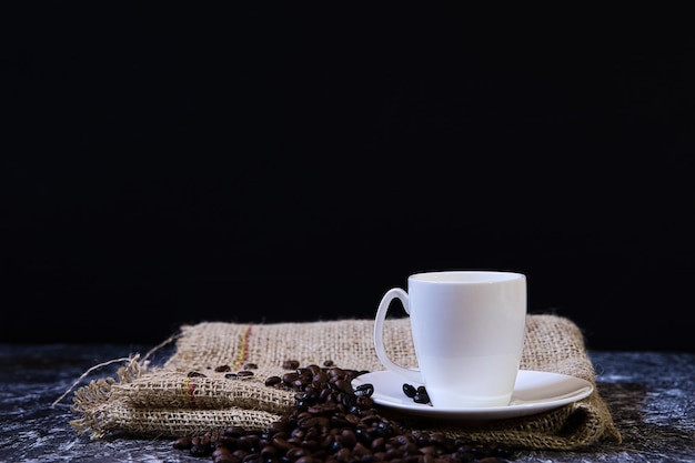 World coffee day concept white porcelain cup with coffee beans