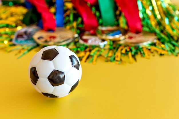 World Cup soccer ball and medals on yellow background