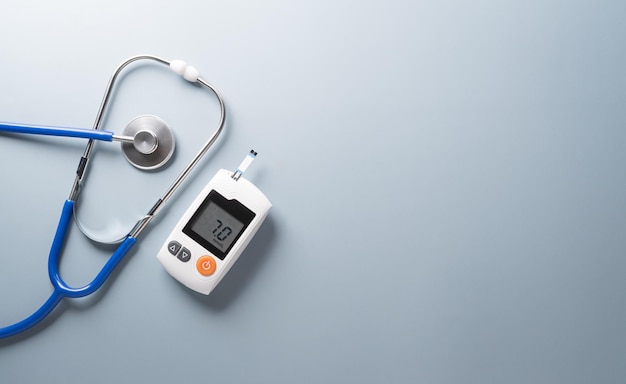 World Diabetes day concept 14 November Top view of blood glucose meter sets and stethoscope on pastel blue background