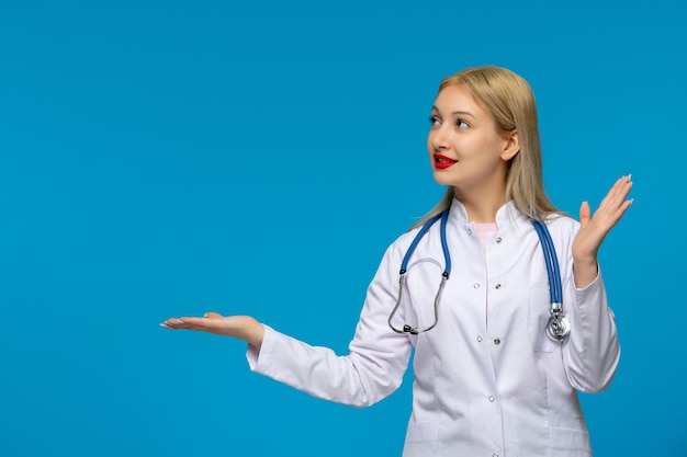 World doctors day happy blonde young doctor looking left with the stethoscope in the medical coat