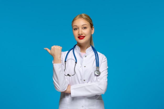 World doctors day smiling doctor pointing to the left with the stethoscope in the lab coat