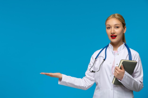 World doctors day surprised cute doctor waving hands with book and stethoscope in the medical coat