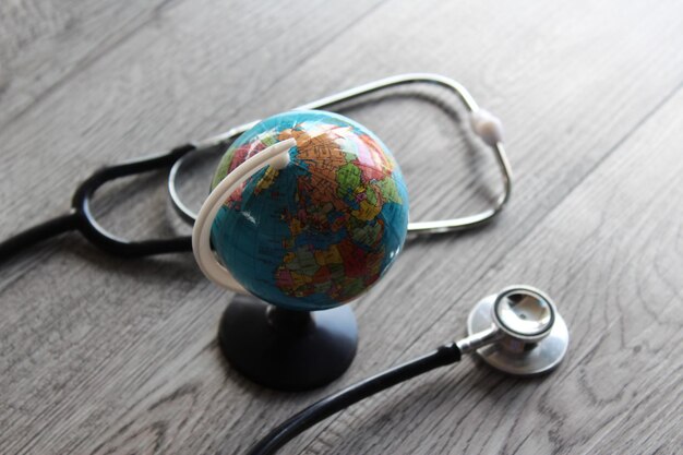 Photo world health day global healthcare medical concept stethoscope and earth globe on wooden table