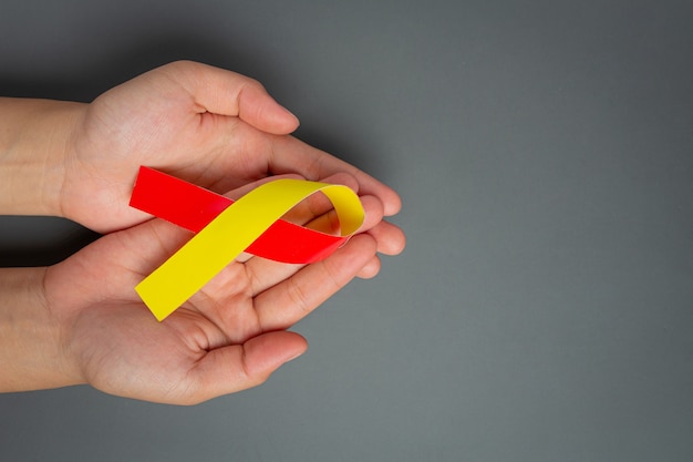 World hepatitis day awareness with red yellow ribbon