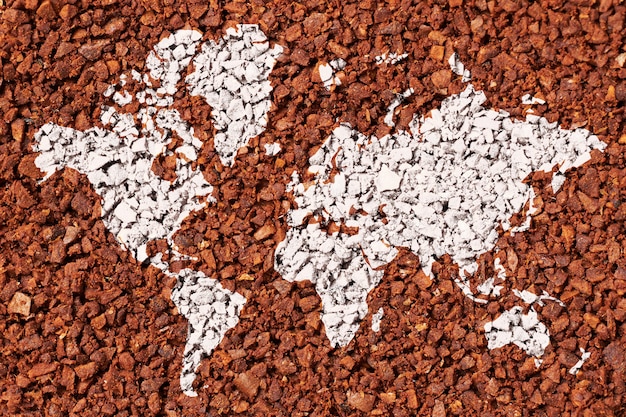 World map on the background of ground coffee as an export concept