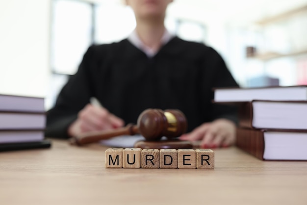 World murder and gavel on judge counter in courtroom punishment of criminal actions causing