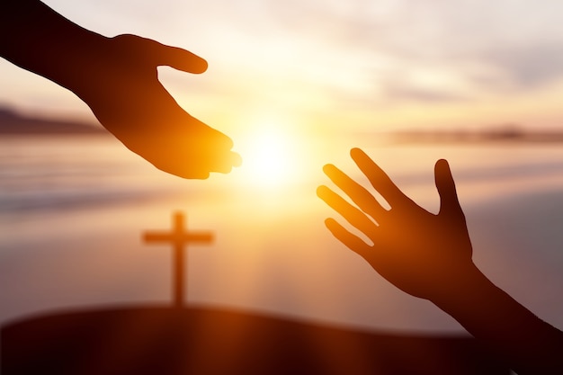 World Peace Day concept: Silhouette of Jesus reaching out hand              - Image