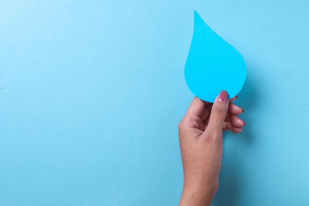 World Water Day save the water Hand holds paper water drop on blue background