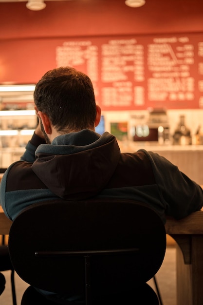 Worried busy man is sitting in cafe and working on complex project Problems at work Man thinking