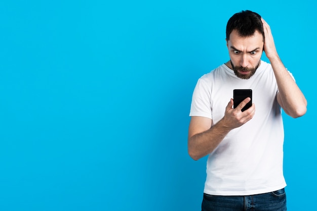 Worried man looking at smartphone