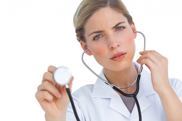 Worried nurse listening to stethoscope