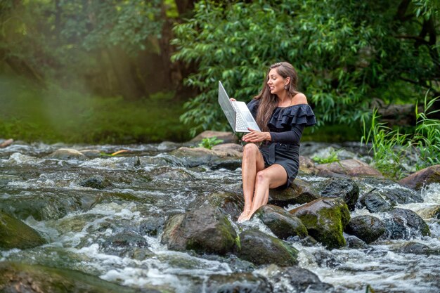 Worried woman pulls out of water laptop that fell into river remote holiday work accident