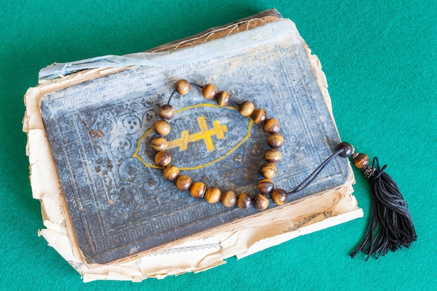 Worry beads on old psalm book on green table