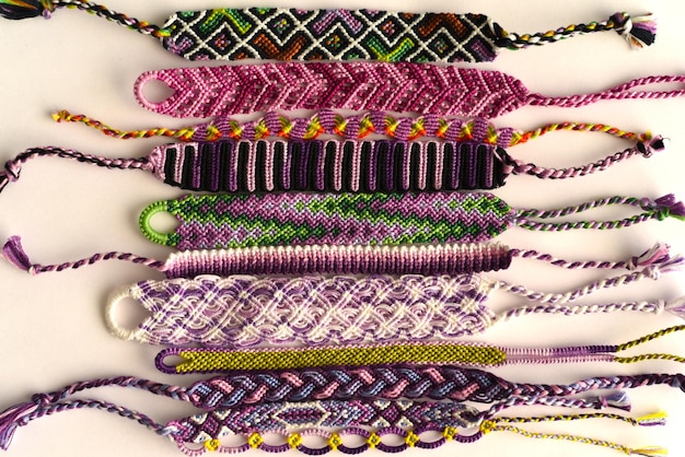 Woven DIY friendship bracelets handmade of embroidery bright thread with knots on white