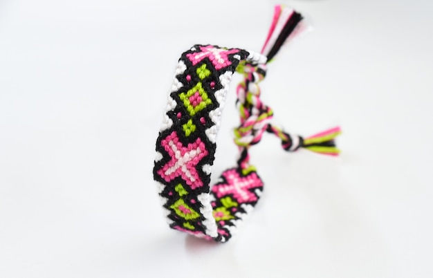 Woven DIY friendship bracelets with bright colorful pattern handmade of thread on white