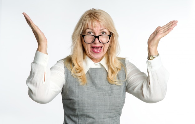 Wow, delight! Mature woman in glasses gesture her emotions on a light background.