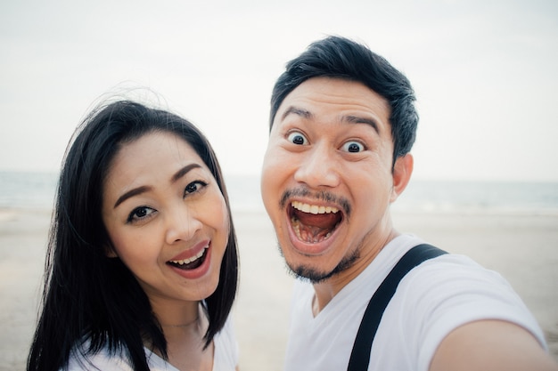 Wow face of couple tourist on romantic beach vacation trip.