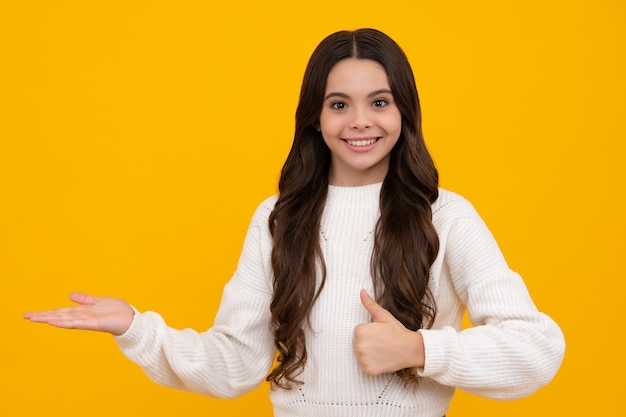 Wow it's unbelievable Shocked teenager child pointing aside at copy space Teen girl pointing with two hands and fingers to the side Happy face positive and smiling emotions of teenager girl