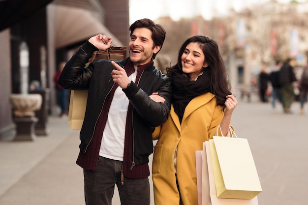 Wow sales Guy pointing on shopwindow shopping wih wife