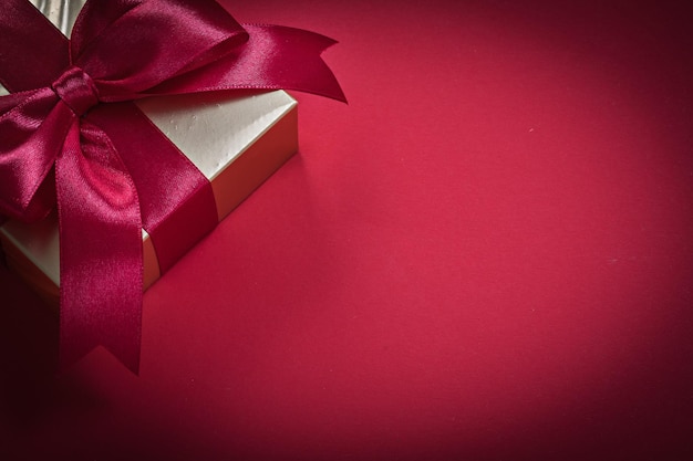 Wrapped present box on red background holidays concept