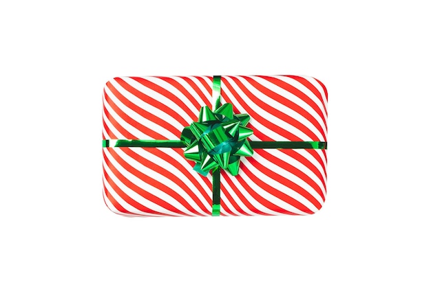 Wrapped red gift box with shiny green ribbon bow object isolated on white background A holiday striped wrapper top view Christmas present new year decoration