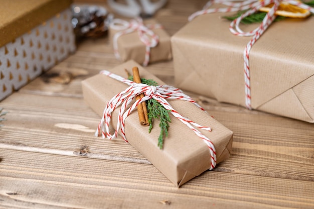 Wrapping christmas gift close up unprepared presents on wooden background with orange cinnamon