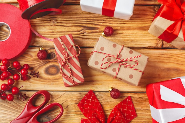  wrapping gift boxes with equipment and decorating items on wooden background