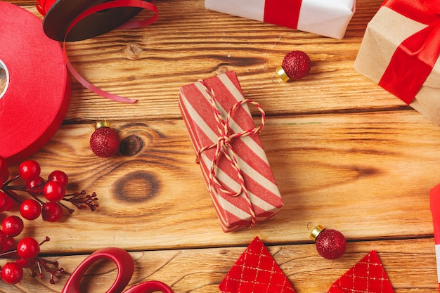  wrapping gift boxes with equipment and decorating items on wooden background