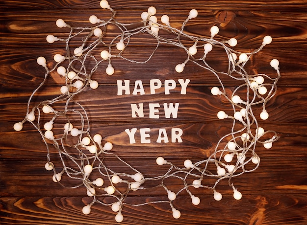 Wreath made of christmas lights on a wooden table. Happy New Year 2021