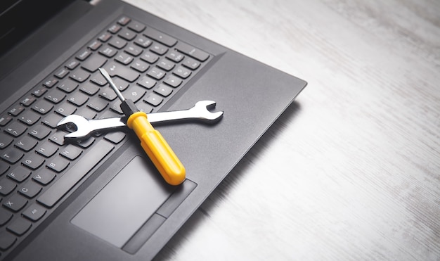 Wrench and screwdriver on the computer keyboard.