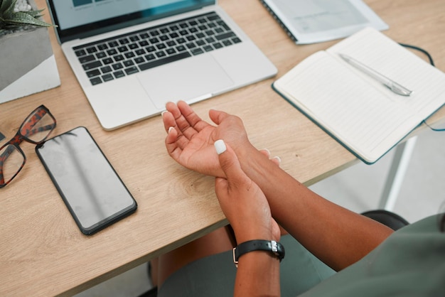 Wrist arm and pain by laptop desk of employee worker suffering from carpal tunnel syndrome at the office Person hand holding painful area inflammation or sore muscle ache from working on computer