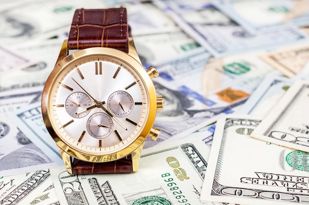 Wrist watch on dollars background Business concept