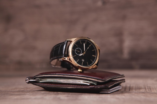 Wrist watch and wallet on the table