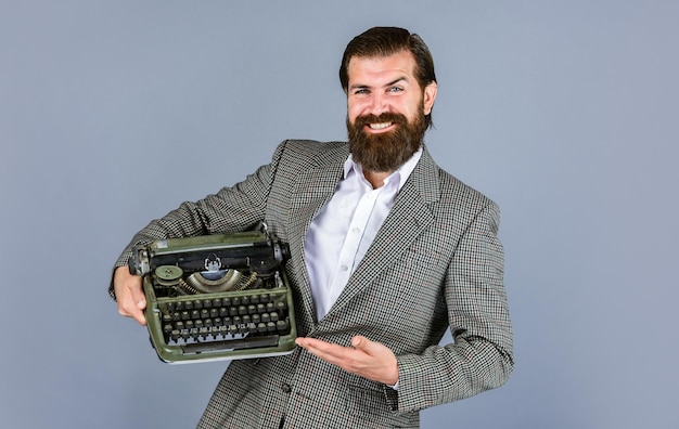 Writer writes with typewriter bearded man in jacket with retro type writer new technology in modern life Man working on retro typewriter in library mechanical vs digital