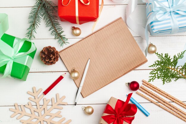 Writing christmas greeting cards. Open notepad with pen on decorated wooden table