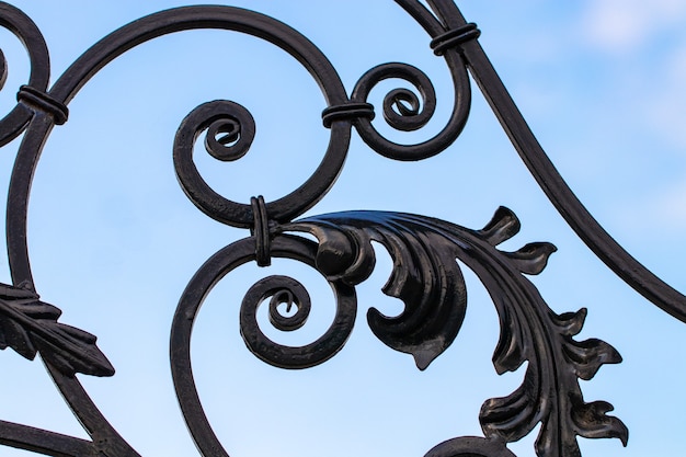 Photo wrought-iron gates, ornamental forging, forged elements close-up.