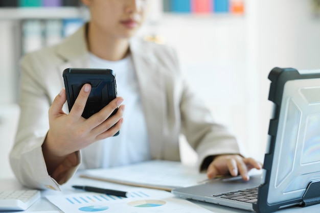 X9Close up young Asian businesswoman is working at office using mobile phone