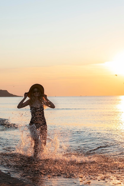 XAA happy girl in a swimsuit and runs along the sea at dawn Vacation and travel concept