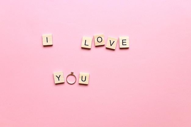 XAI love you made of wooden letters on a pink background Marry me Engagement ring Postcard I love you