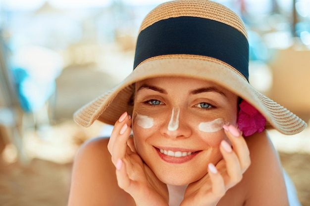 XAWoman smile applying sun cream on face Skincare Body Sun protection sunscreen