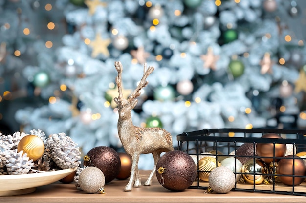 Xmas decorations with pine cones on wood table with copy space against the background of a Christmas tree with illumination